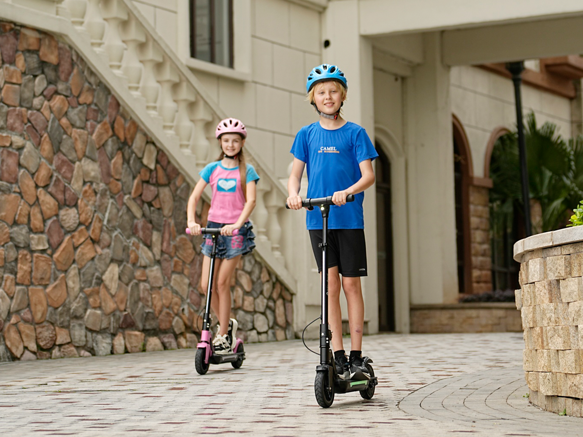 Two helmeted young riders standing on iSinwheel S7 electric scooters